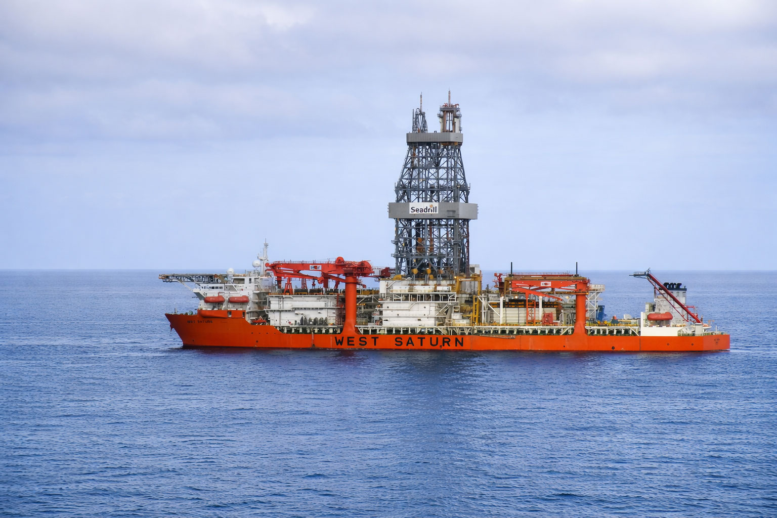 The image shows the West Saturn, an ultra-deepwater drillship operated by Seadrill, a leading offshore drilling contractor. Operator: Seadrill. Purpose: The West Saturn is a drillship used for offshore oil and gas exploration and production, drilling wells in deepwater environments. Technological Advancement: The West Saturn is known for its advanced technology, enabling it to operate efficiently in challenging offshore conditions.